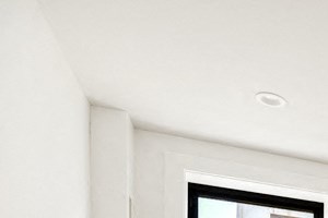 the living room of an apartment with wood floors and two windows